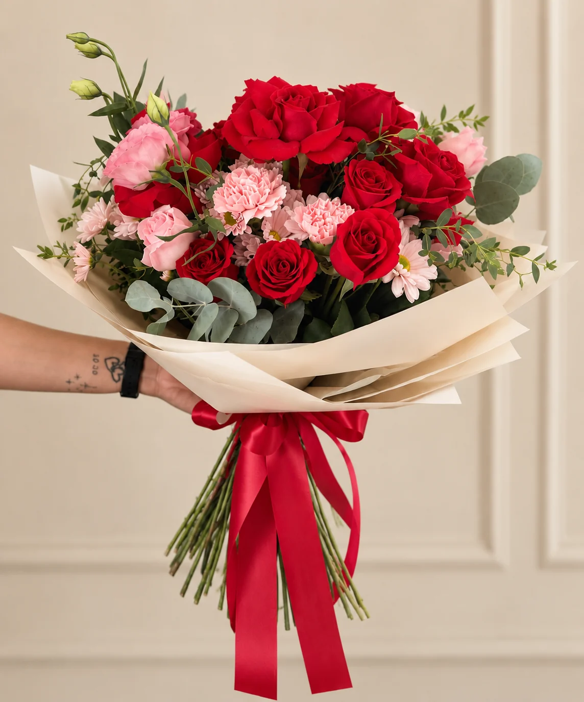 Ramo Blush con flores rojas y rosadas y envoltura clara, Dos Gardenias.