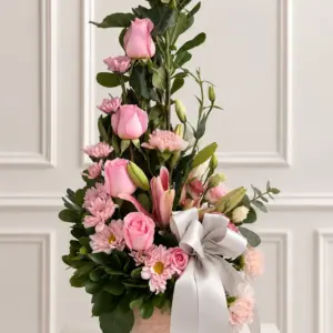 Arreglo Serenidad vertical con rosas rosadas en base de cerámica y listón blanco.