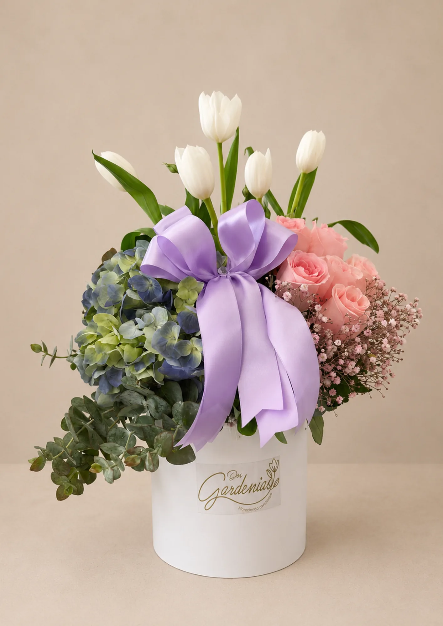 Arreglo Emilia de Dos Gardenias: 5 tulipanes blancos, 5 rosas en tono rosa, hortensia de invernadero y finos follajes